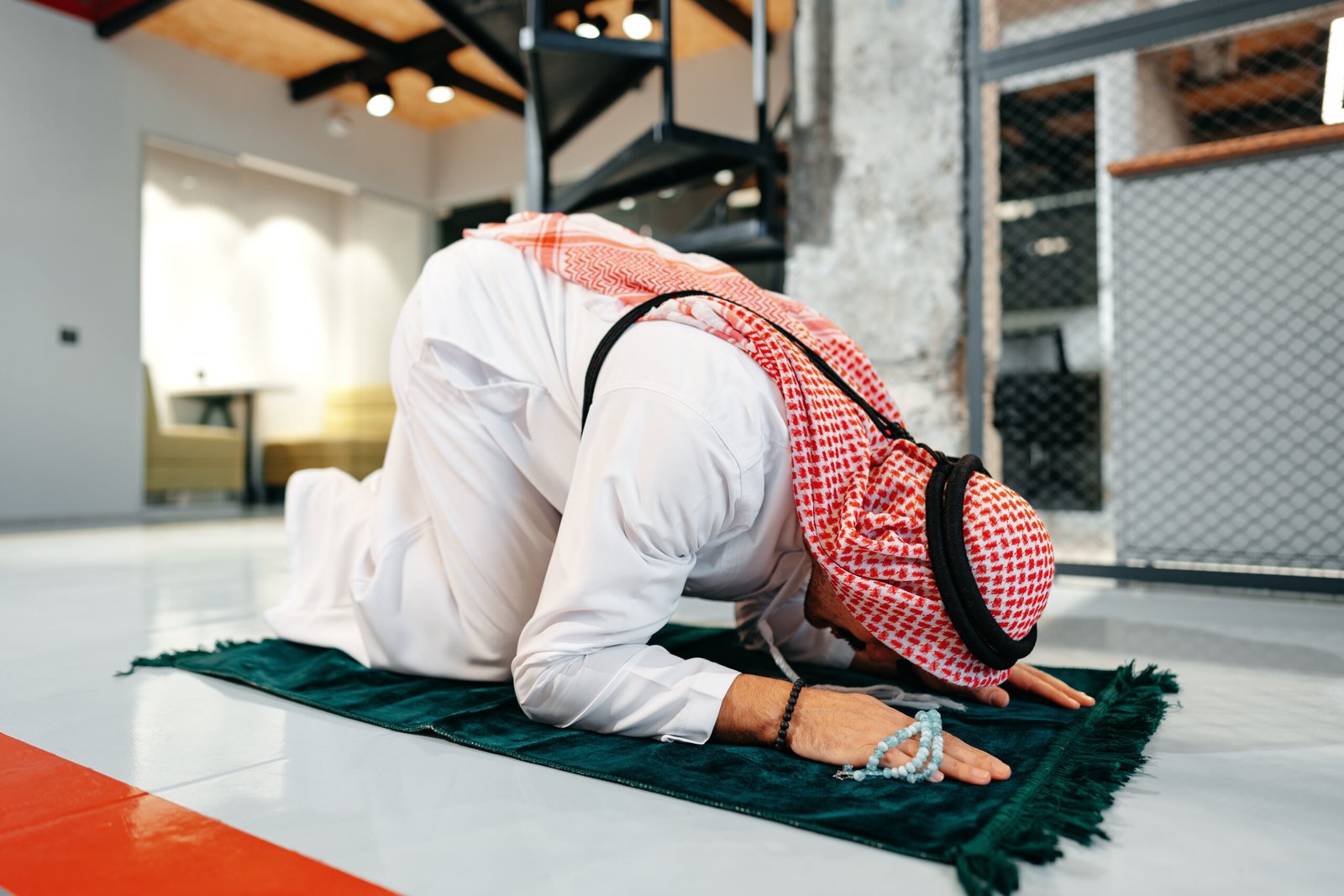 Man performing a Sajdah on a prayer mat showing the importance of Prayer in Islam.