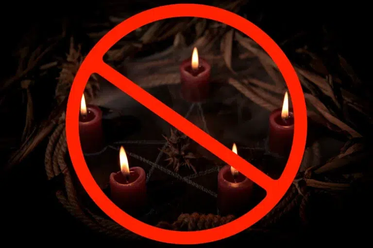 Image of burning red candles arranged in a circle with dark, ritualistic elements in the background. A large red prohibition symbol overlays the image, signifying the forbidden nature of black magic in Islam.