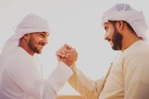 Two men greeting each other with a handshake, symbolizing Brotherhood in Islam, unity, and mutual respect among Muslims.