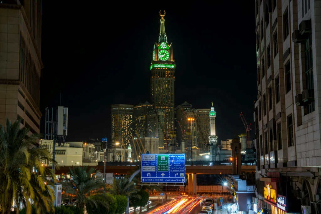 Night View of Makkah Clock Tower Illuminated with Vibrant Lights Overlooking the Busy Streets of Makkah.