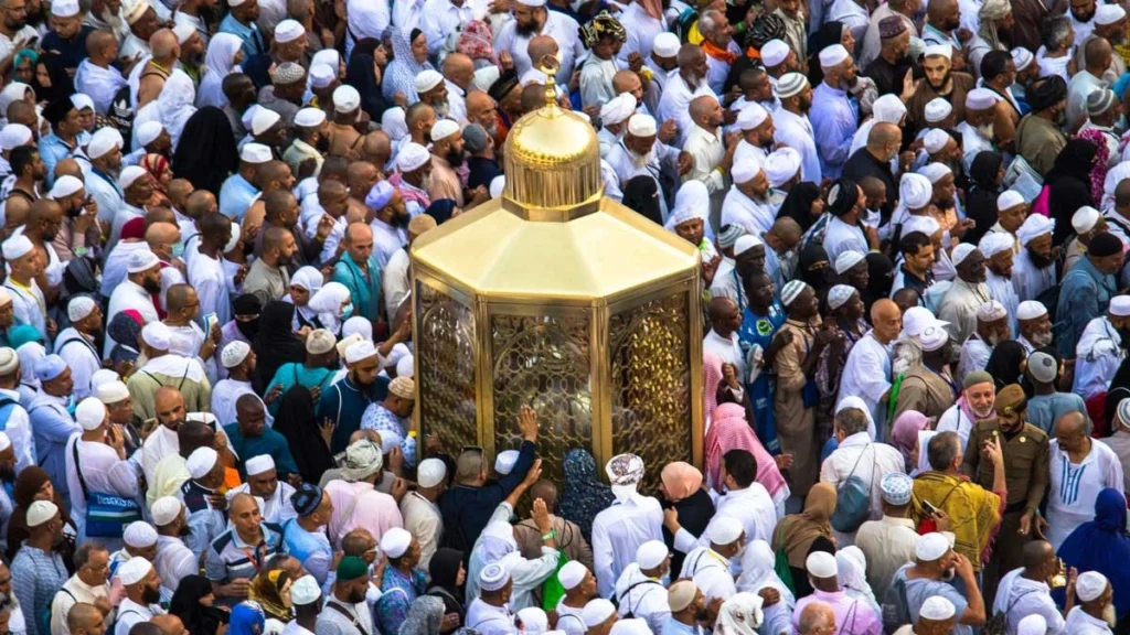 Pilgrims gathered around the Maqam Ibrahim, the golden enclosure containing the footprint of Prophet Ibrahim (AS), near the Kaaba in Masjid al-Haram, Mecca.