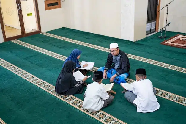 An Islamic teacher sitting on a prayer mat in a mosque, guiding a group of children studying the Quran.