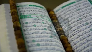 Open Quran with beads, highlighting the benefits of Surah Yaseen, a significant chapter in Islam known for its spiritual blessings and guidance.