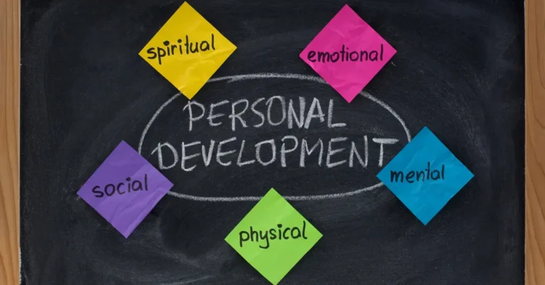 Personal growth and self-development concept showing spiritual, emotional, social, physical, and mental aspects written on colorful notes around a chalkboard.