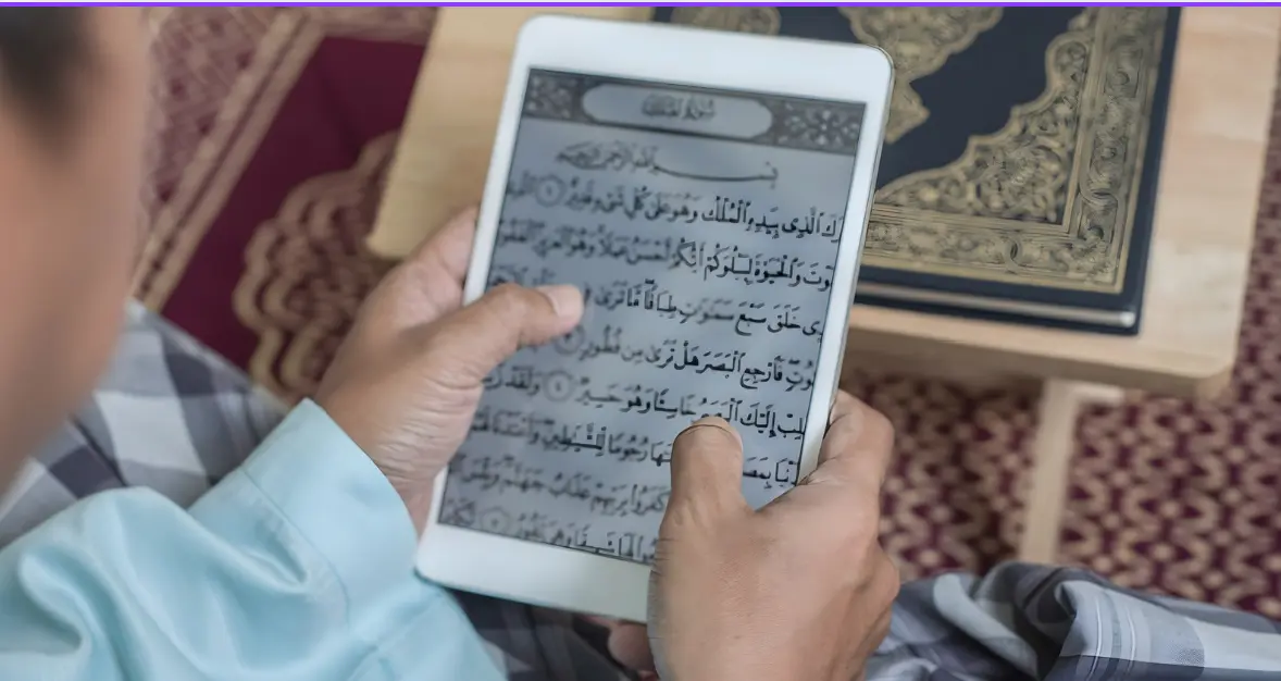 A person reading the Quran on a tablet with an open Quran beside them, symbolizing the benefits of learning Quran online through digital platforms for easy access and spiritual growth.