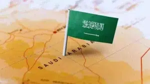Saudi Arabian flag placed on a map highlighting the location of Saudi Arabia in the Middle East